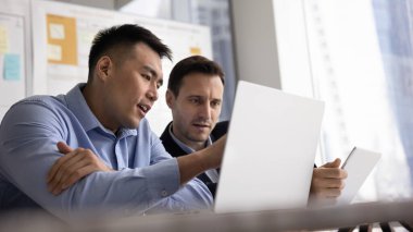 Çok ırklı takım arkadaşları, iş ilişkilerini çözmek için dijital tablet ve dizüstü bilgisayar kullanan ortaklar, sunumu gözden geçirmek, müşteriyle yapılacak toplantı için hazırlanan materyaller