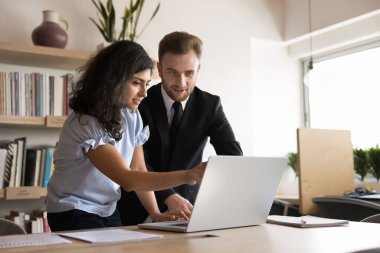 Genç Hintli bir kadın bilgisayarını kullanarak bilgi araştırıyor, veriler üzerinde noktalar, detayları netleştiriyor, odaklanmış görünüyor, birlikte çalışma ofisinde verimli bir takım çalışması yapıyor. Eğitim, danışmanlık.