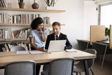 Ofiste dizüstü bilgisayar kullanan iki çok ırklı iş arkadaşı. Hintli kadın akıl hocası erkek meslektaşlarına görevlerinde ya da yeni kurumsal yazılımlarda yardımcı olur, verileri açıklar, beyin fırtınası, fikir paylaşımı ve takım çalışması yapar.