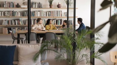 Hintli kadın liderliğindeki brifinge çok ırklı bir ekip katılıyor, mevcut veya gelecek projelerin hedeflerini tartışıyorlar, devam eden görevleri gözden geçiriyorlar, ticari hedeflere ulaşmak için fikir ve stratejiler geliştiriyorlar.