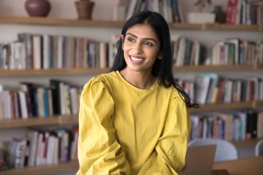 Hintli kadın ofiste mola verir, olumlu ve düşünceli bir ifadeyle mesafeye bakar, görev ya da proje üzerine kafa yorar, verimli bir iş gününden memnun olur. İçerideki öğrenci ya da personel portresi