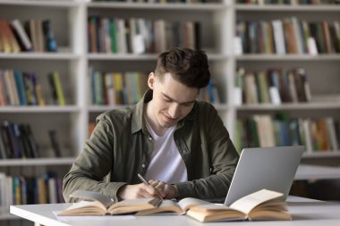 Üretken öz öğrenim. Gülümseyen, çalışkan erkek lise öğrencisi, yaratıcı akademik çalışmalar yazıyor. Sınav için hazırlan. Bilimsel araştırmalar yap.