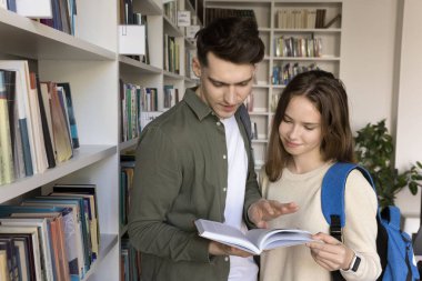 Kitaplarla bağ kurmak. İki farklı nesil z kolej öğrencisi arkadaş kütüphanede kağıt cilt okumaktan zevk alıyorlar geleneksel öğrenme materyallerinden esinlenen yeni fikirleri keşfediyorlar arkadaşlık akademik çıkarlarını birleştiriyorlar