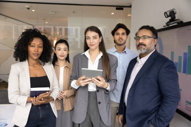 İş konusunda uzmanlar. Grup portresi ciddi bir şekilde kendinden emin çok ırklı iş adamları ajansı ekibi elinde kağıtlarla müşterilere stratejik çözümler rehberliğinde yardım etme konusunda yetenekli kamera görüntülerine bakıyorlar.