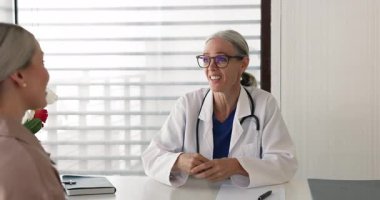 Klinikteki masada oturan, el sıkışan, ziyaretini bitiren, saygı gösteren, nitelikli tıbbi hizmetler sunan kadın hastalarla samimi pratisyen hekim konuşmaları. Sigorta, sağlık hizmetleri