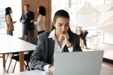 Şirket rutini. Meşgul genç profesyonel kadın çalışan yönetici resmi takım elbise üzerinde çalışıyor defter üzerinde çalışıyor proje belgeleri okuyor mali rapor inceleme önerisi üzerinde düşünüyor ekrandaki verileri analiz ediyor