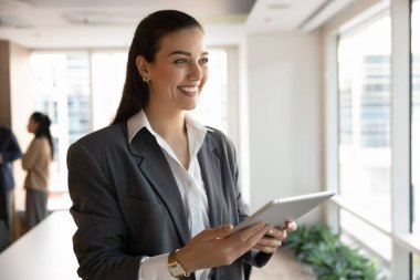 Uzman arıyorum. Portre gülümseyen genç kadın işletme sahibi avukat sekreter modern işyerinde ayakta duran dijital tablet cihazı yenilikçi projeler üretmek için beyin fırtınası yapıyor