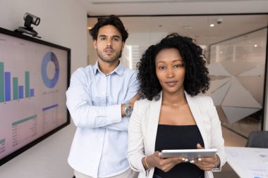Bizim hakkımızda. İş yeri portresi kendine güvenen iş adamları genç erkek kadın yöneticilerin çok kültürlü takımı takım liderleri modern ofiste dijital aletlerle kameraya bakıyorlar.