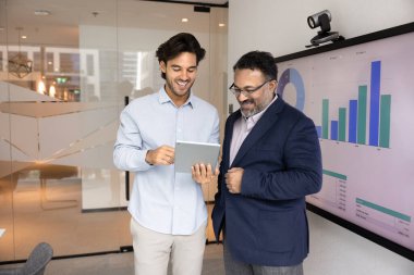 Ürün ya da hizmet gösterisi. Milenyum yöneticisi proje geliştiricisi modern ofisteki yeni iş teklifini tablet bilgisayar kullanan olgun erkek müşteriye açıkla