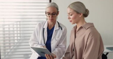 50 'li yaşlardaki olgun bir doktor 30' lu yaşlardaki genç hastalara gösterilen tedavi planını, gülümsemeyi, el sıkışmayı, güven ya da anlaşmanın bir göstergesi olarak açıklıyor. Başarılı tıbbi danışmanlık, modern sağlık hizmetleri