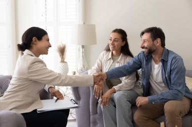 Mutlu evli çift aile psikologu ile tokalaşıyor, ziyaretlerini ve terapilerini başarıyla tamamlıyorlar. Menajer ve memnun müşteri tokalaşması, emlak anlaşması, satın alma veya satış hizmetleri