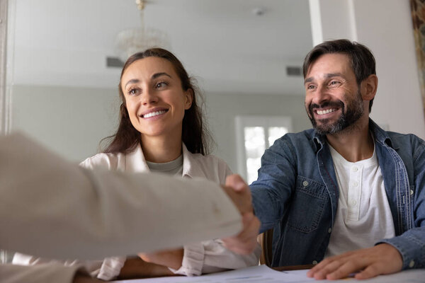 Sales manager, attorney or broker shaking hands with clients start or finish formal meeting. Successful completion of business transaction, buying house, signing contract, or finalizing partnership