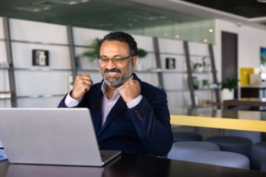 Neşeli, kıdemli Hintli ürün sahibi kazananı heyecanlandırıyor. Bilgisayarda yumruklar, satış artışı, internet girişimi başarısı, profesyonel zafer. Fotokopi alanı ile gizli resim