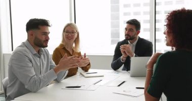 Genç 30 'lu yaşlardaki Arap işadamı iş arkadaşlarıyla konuşuyor, gülümsüyor, keyifli, dost canlısı ve verimli bir takım çalışması yapıyor, ortak görev tartışması yapıyor, sabah brifinginde çözümler arıyor.