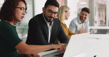 Modern çalışma ofisindeki dizüstü bilgisayarda ortak görev üzerinde çalışan iki takım arkadaşı, görüşleri ve çözümleri paylaşıyor, defter ekranına bakıyor, öğrenme verilerine bakıyor, görüşü açıklıyor, öneriyi gözden geçiriyor