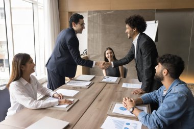 İş ortaklığı. Resmi takım elbiseli iki genç, üst düzey yöneticiler, yönetim kurulu başkanlarının el sıkışması, müzakere sözleşmesi görüşmeleri, işbirliği ve birleşme anlaşması üzerinde uzlaşma sağlandı.