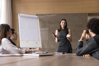 Etkili basit strateji. Gülümseyen iş kadını sunucu şirket çalışanları için iş konferansında çeşitli iş arkadaşlarıyla sohbet ederek pazar kriterlerini beyaz tahta kullanarak sağlayın.