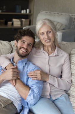 Annenle tatlı rüyalar. Gülümseyen genç bir çocuk yetişkin bir torun koltukta rahatla sevgi dolu bir anneye sarıl büyük anne rüyalarını paylaş gelecek planlarını tartış mutlu bir gelecek için vizyon yarat