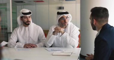 Arap ve Avrupalı iş adamları el sıkışıyor, anlaşmayı tamamlıyor, şirket yönetim kurulunda başarılı bir resmi toplantı veya müzakere süreci gerçekleştiriyor. Anlaşmak, ortaklık kurmak.