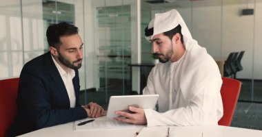 Ofis masasında oturan iki işadamı anlaşarak el sıkışıyor. Arap yönetici müzakere sırasında veya istemci ile toplantı sırasında bilgi verir, sunum gösterir, şirket hizmetlerini tablette açıklar