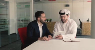 İspanyol ve Arap işadamları, iş arkadaşları tablet kullanarak, görev tamamlama üzerinde çalışarak, müşteriyle toplantı yaparak, konferans odasında yapılan görüşmelerde sözleşme detaylarını anlatırlar.