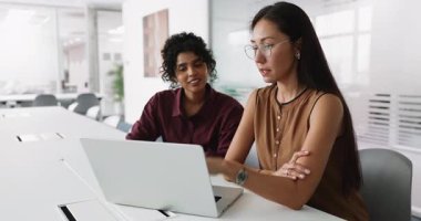 Genç Asyalı iş danışmanı kadın şirket desteği veriyor, Hintli kadın iş arkadaşına, müşteriye tavsiyeler veriyor, dizüstü bilgisayar kullanıyor, online içeriği açıklıyor, internet satış stratejisi