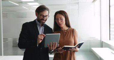 İşbirliği, profesyonel iletişim, şirket ürünlerinin çevrimiçi satışlarını izlemek, internette gezinmek, konuşmak, gülümsemek için dijital tablet kullanan birkaç pozitif iş arkadaşı