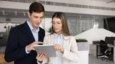 Tablet bilgisayar kullanan birkaç genç İspanyol iş arkadaşı. Kadın analist, profesyonel uzman, elektronik belgeyi açıklayan danışman, erkek arkadaşa online uygulama