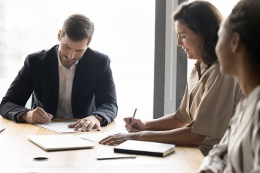 Belge imzalıyorum. Odaklanmış genç iş adamı avukat broker danışmanı olgun kadın müvekkil sigorta poliçesi kopyalarına imza attı. Çeşitli iş ortakları anlaşma yaptıktan sonra anlaşma imzaladılar