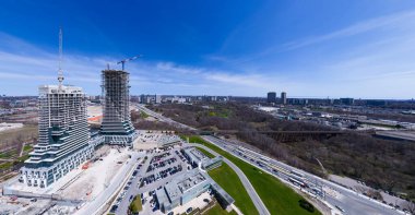 Yeni binaların yakınındaki ve etrafındaki hava manzaralı inşaat alanı. Gökdelenlerin ve yüksek binaların modern mimarisi. Gayrimenkul kavramı. Boş çalışma alanı, vinçler ve ağır makineler