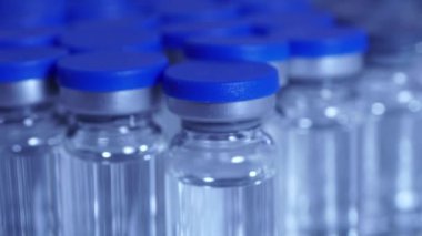 COVID-19 aşısı ve şırınga hareket ediyor. Coronavirus aşısı olan ampuller ve şişeler doktor masasında hazır. Tıp uzmanları tarafından yapılan kas içi aşılama..