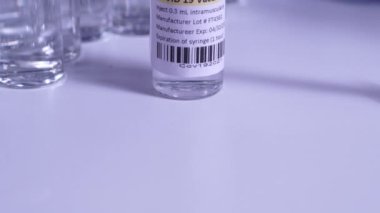 COVID-19 aşısı ve şırınga hareket ediyor. Coronavirus aşısı olan ampuller ve şişeler doktor masasında hazır. Tıp uzmanları tarafından yapılan kas içi aşılama..