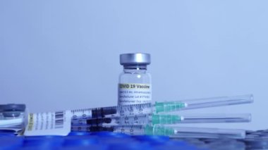 COVID-19 aşısı ve şırınga hareket ediyor. Coronavirus aşısı olan ampuller ve şişeler doktor masasında hazır. Tıp uzmanları tarafından yapılan kas içi aşılama..