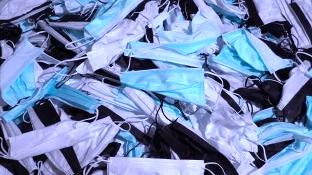 テーブルの上のコロナウイルスのゴミ 使い捨て医療用マスクは個人用保護具の山を使用した Covid 19パンデミックによる外科的バイオハザード廃棄物処理 — ストック動画