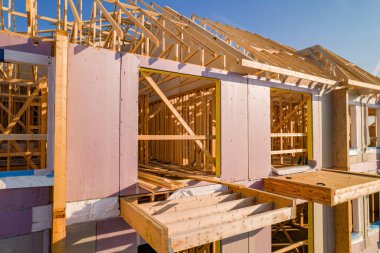 Şişe iskeleti ve ahşap çerçevelerden yapılmış inşaat halindeki yeni şehir konutları. Ev ya da aile evi inşaatı ve gayrimenkul.