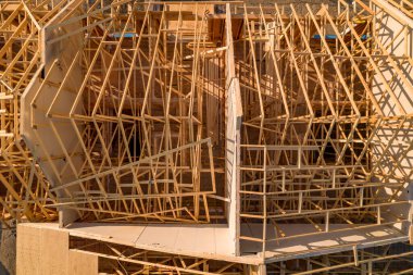 Şişe iskeleti ve ahşap çerçevelerden yapılmış inşaat halindeki yeni şehir konutları. Ev ya da aile evi inşaatı ve gayrimenkul.