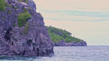 Tobermory 'deki Indian Head Koyu, Ontario Kanada' daki turkuaz mavi su ve yeşil çam ormanı. Bruce Patikası, Gürcistan Körfezi Yolu ve Kıbrıs Gölü yakınlarındaki Bruce Yarımadası Ulusal Parkı 'nda yaz günü.