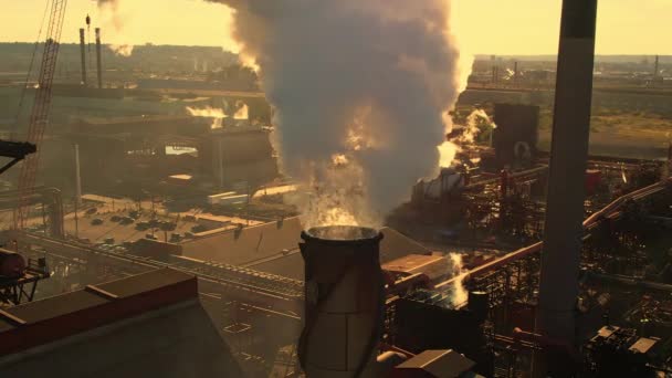 日没の時間と黄金の時間の間に鋼管 濃い煙の後ろに日光 冶金工場と煙雲は煙突から来ている温室効果ガスゾーン層を作成します 気候変動 — ストック動画