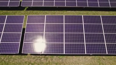 Flying over solar power cells panels at power station in the field. Green energy and ecology innovation for preservation of nature and avoid environment impact. Photovoltaic solar panels technologies