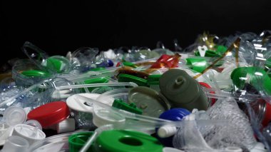 Tek kullanımlık plastik çöp. Geri dönüşümsüz plastik atıkla çöp sahalarının aşırı kirlenmesine dikkat çekmek. Masanın üzerinde biyolojik olarak çözünemeyen zehirli bir çöp var. Çevre sorunları.