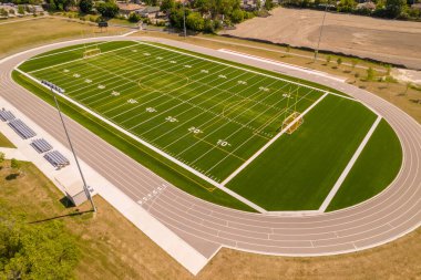 Oyuncuları olmayan boş futbol sahasının en üst görüntüsü. Çimen, beyaz boya çizgileri ve işaretleri olan bir futbol sahası. Yeşil yüzeyi olan spor futbolu ve futbol. Eğlence etkinliği.