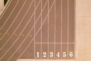 Açık hava spor stadyumundaki koşu pisti manzarasının üzerinde. Atletizm stadyumu ve koşu pisti boyunca yarışan atlet POV. Rekabet sporları ve şampiyon sıkı çalışma. 