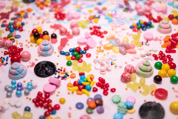 糖的各种颜色 大小和味道与真正的白糖混在桌上 甜的小吃 巧克力 果冻豆 糖蜜和蛋糕洒 — 图库照片