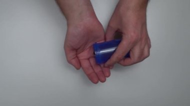 Yetişkin adam elindeki plastik şişeden hapları alıyor. Reçeteli ilaç yönetimi. Sağlık, eczane ve tedavi konsepti, ellerin üst görünümünü kapatın.