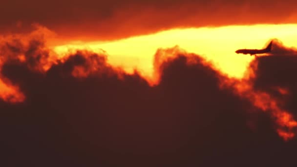 Widok Sylwetki Samolotu Pasażerskiego Przelatującego Przez Epickie Pomarańczowe Czerwone Niebo — Wideo stockowe