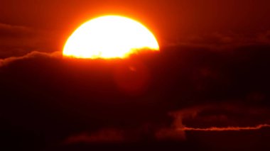 Büyük parlak sarı güneş diski gün batımında batıyor. Gökyüzü ve gökyüzü çizgisi. Batan güneşin şaşırtıcı turuncu kırmızı sarı renkleri. Canlı renkler ve gün batımı.