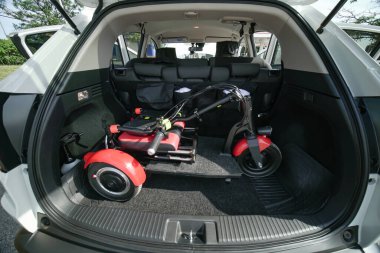 Elektrikli tekerlekli sandalye ya da katlanabilir üç tekerlekli hareket kabiliyeti olan scooter bagajda. Hareket kabiliyeti engelli ya da hareket sorunu olan insanlar için. Hareket özgürlüğü ve günlük yaşam bağımsızlığı.  