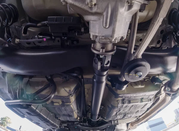 Auto mechanic view of bottom of the car. Rear differential axle wide angle, rear suspension system and components of exhaust system in passenger city car. All wheel drive system vehicle.