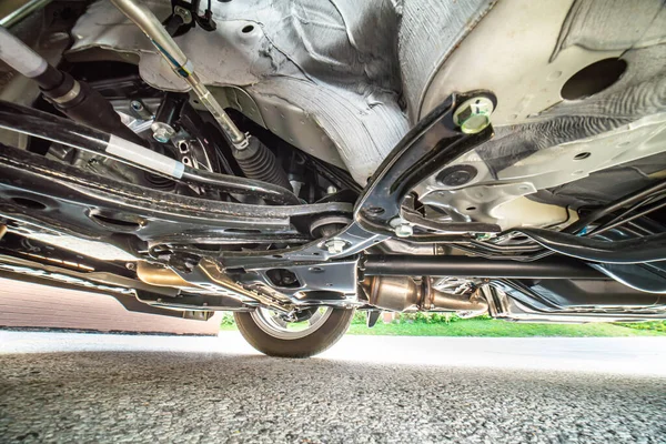 Bottom car view for safety inspection. Concept of garage services, used vehicle appraisal, car points inspection, automobile certification. Checking on shock absorbers damaged and suspension parts.