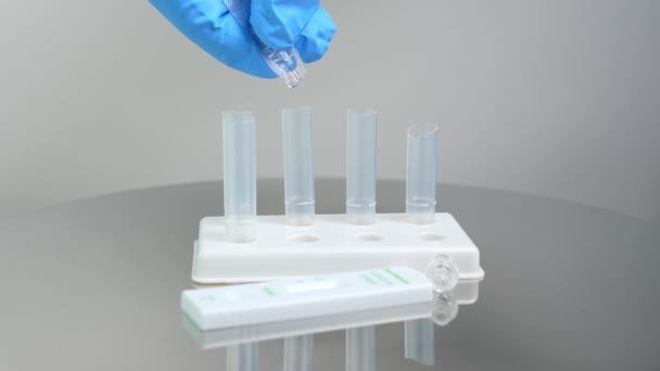 护士投放试剂提取缓冲管进行抗原快速检测 一套塑料管和测试盒带在金属医疗桌上 医学实验室概念中的Covid 19快速测试 — 图库视频影像